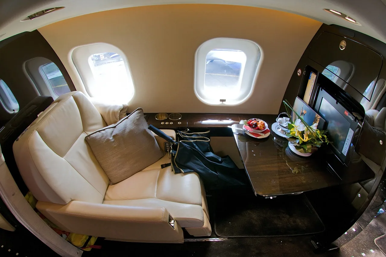 Private jet cabin interior in cream leather and burr walnut